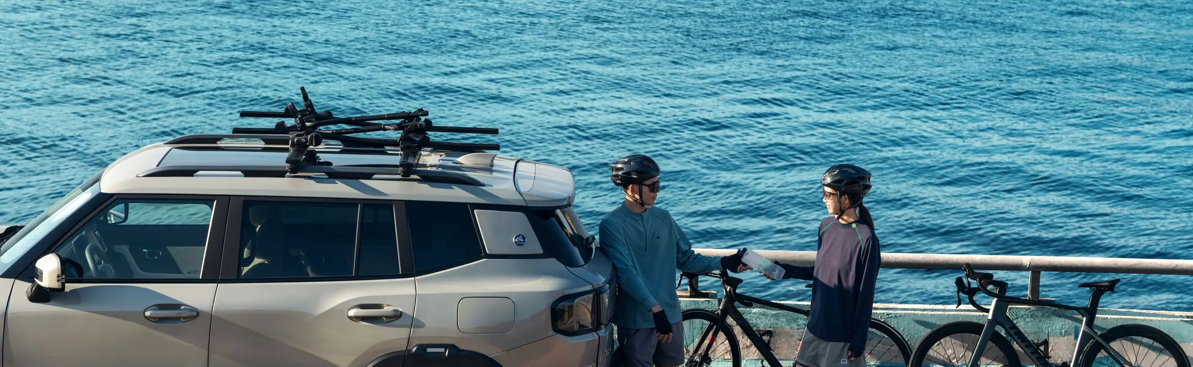 Une voiture équipée d’un porte-vélo et d’un coffre de toit, prête à partir